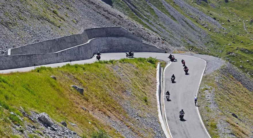 Motocykliści przemierzają kręte trasy w górach, ciesząc się wolnością i pięknymi widokami. To idealne miejsce na odkrywanie polskich tras motocyklowych.