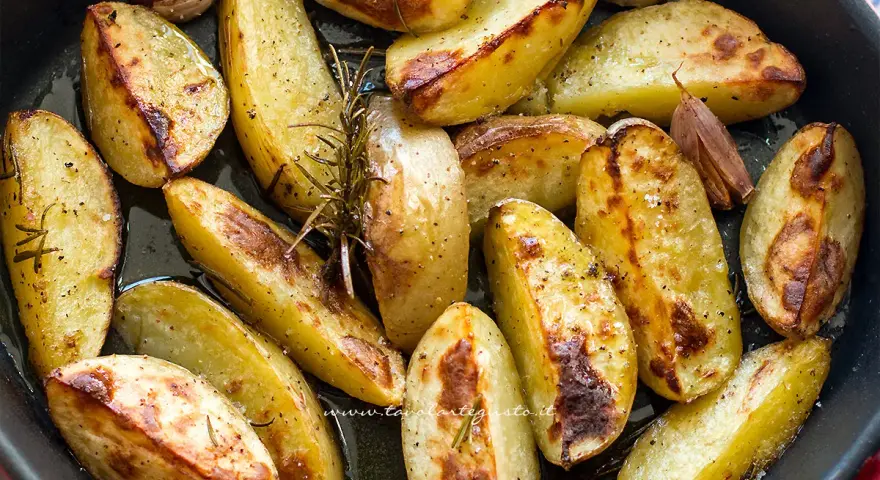 Patate al forno croccanti, dorate e profumate al rosmarino e aglio, pronte per essere gustate.