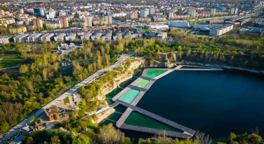 Widok na krakowski Zakrzówek z basenami i drewnianymi pomostami. Sprawdź zakrzówek cennik i zaplanuj relaks.
