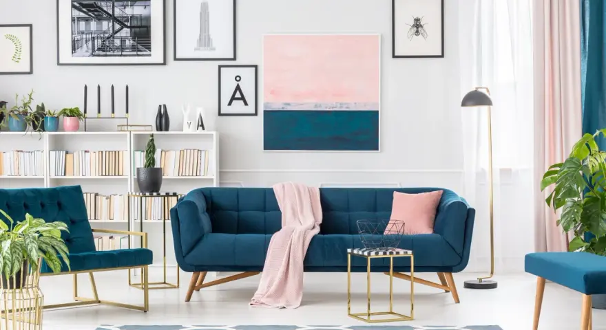 Granatowa sofa i fotele z pudrowym różem tworzą elegancką przestrzeń.