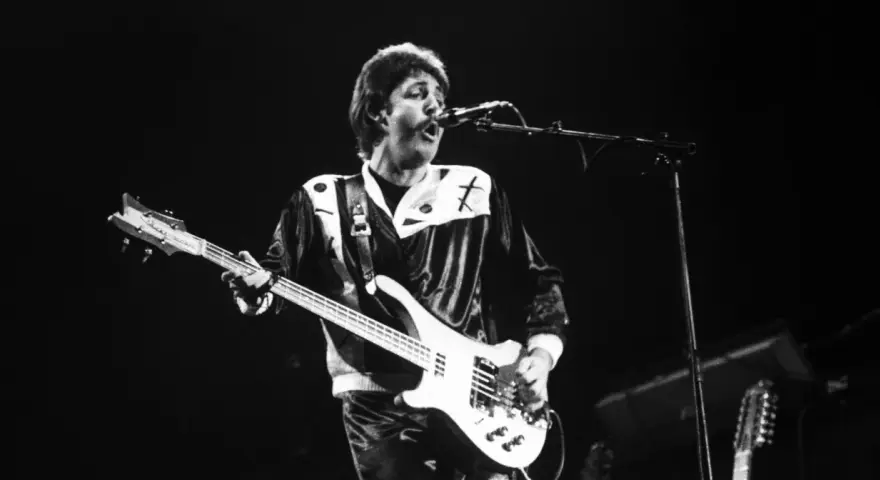 Paul McCartney, jeden z legendarnych amerykańscy piosenkarze lat 80., gra na gitarze basowej podczas koncertu.