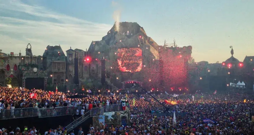 Tłum ludzi na największym festiwalu muzycznym na świecie, z wulkaniczną sceną i pokazem sztucznych ogni.