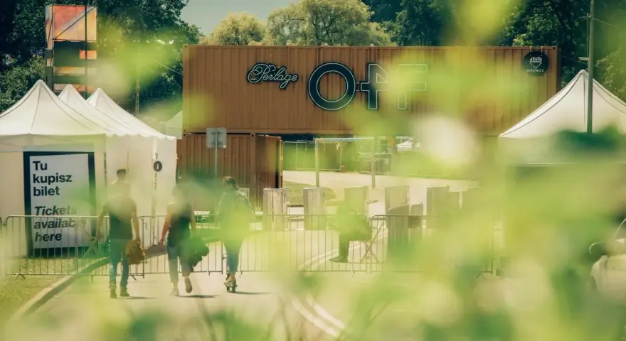 Ludzie idą po bilety na OFF festival. W tle widać logotyp festiwalu.