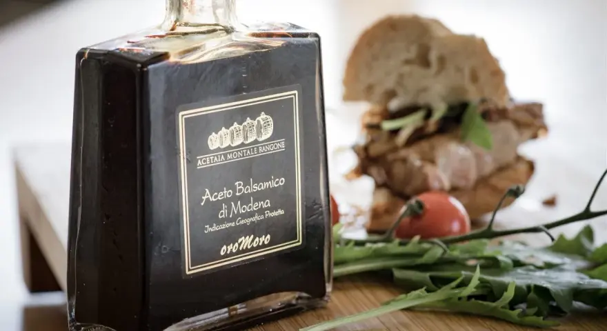 Butelka octu balsamicznego z Modeny obok kanapki i rukoli. Czy ocet balsamiczny jest zdrowy?