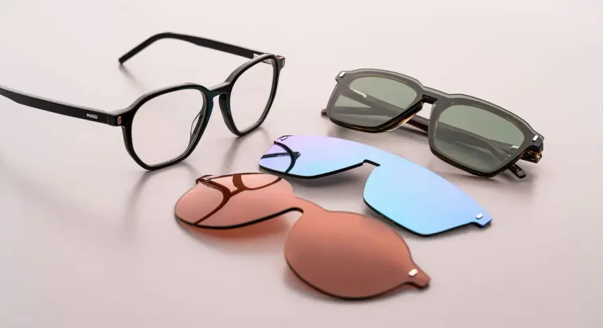 Occhiali da vista Hugo Boss AG con lenti intercambiabili: una montatura nera, lenti da sole marroni, azzurre e verdi.