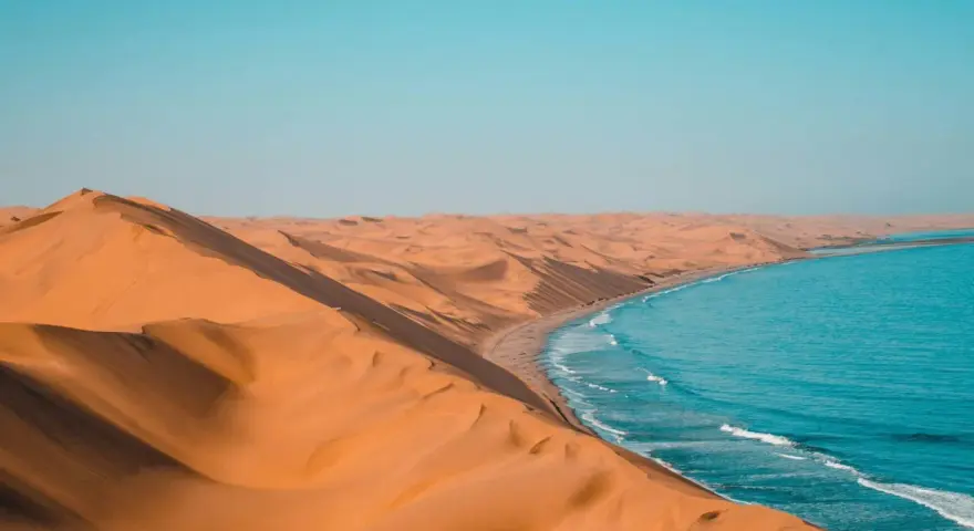 Piasek Namibii spotyka ocean. Niesamowite krajobrazy i ciekawostki o tym miejscu zapierają dech w piersiach.