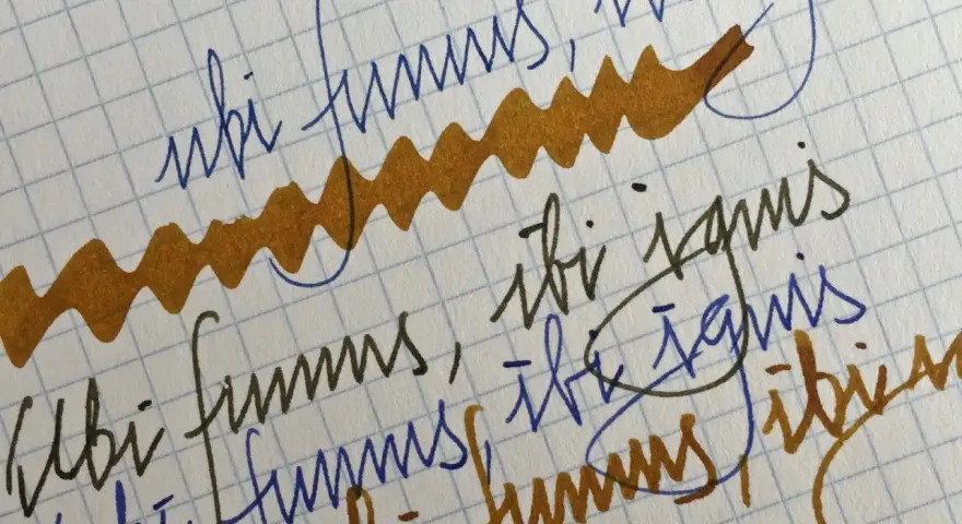 Papel cuadriculado con escritura a mano en tinta azul y marrón. Se lee "ubi fumus, ibi ignis" repetidamente.