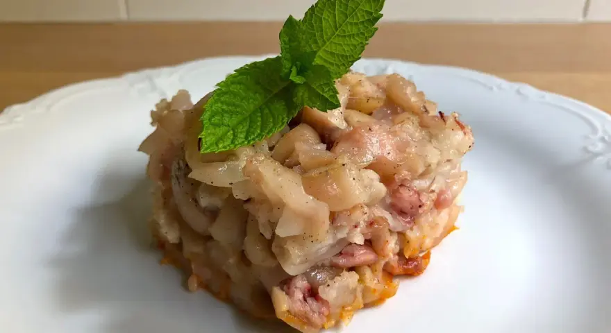 Deliciosa terrina de manitas de cerdo, con trozos tiernos y gelatinosos, coronada con una hoja de menta fresca.