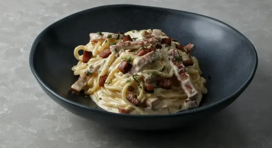 Pyszne spaghetti carbonara z chrupiącym boczkiem i kremowym sosem, idealnie ugotowany makaron al dente.