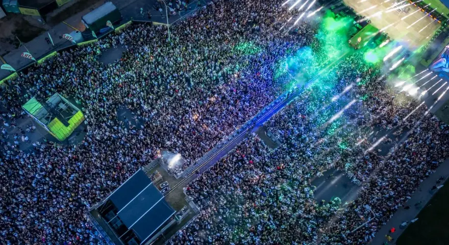 Tłum ludzi na koncercie podczas Łódź Summer Festival 2026. Kolorowe światła i dym tworzą niesamowitą atmosferę.
