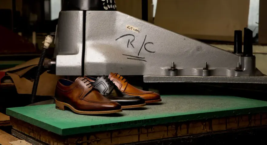 Scarpe eleganti in pelle marrone e nera, pronte per essere lavorate per ammorbidire la pelle.