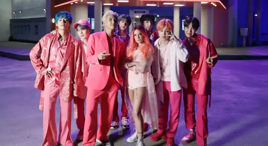 BTS und Halsey in pinken Outfits, ein Bild, das die vielen BTS Spotify Streams feiert.