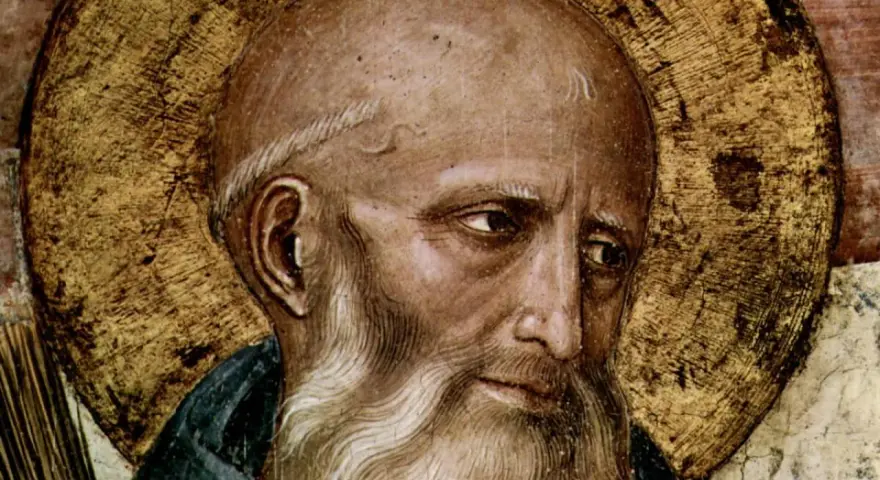 Close-up of a fresco depicting St. Benedict, with a golden halo and a wise, weathered face.