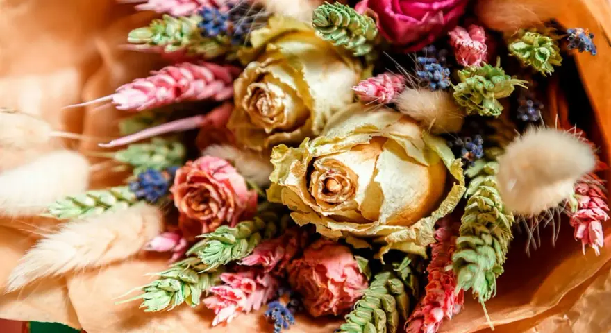 En vacker bukett med torkade blommor, som rosor och lavendel, visar hur torkar man blommor för att bevara deras skönhet.