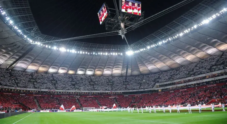 Stadion Narodowy w Warszawie, z pełną widownią, która tworzy biało-czerwony wzór. Jego imponująca pojemność robi wrażenie.