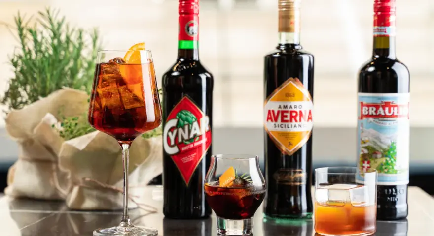 Verschiedene Campari-Sorten: Cynar, Averna und Braulio, serviert in Gläsern mit Eis und Orangenscheiben.