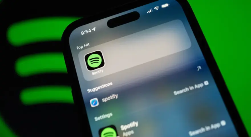 Telefon z aplikacją Spotify, sugerującą muzykę w jakości **spotify lossless**. Zielone logo Spotify w tle.