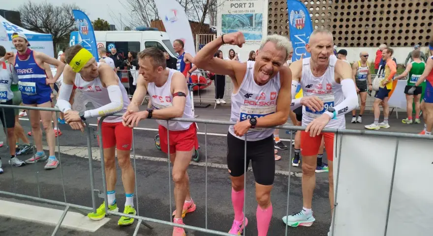 Marcin Konieczny i inni biegacze w biało-czerwonych strojach czekają na start.