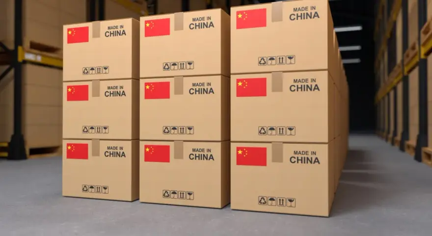 Pudełka z napisem "Made in China" i flagą Chin w magazynie. To przykład tego, co to jest import – towary produkowane za granicą.