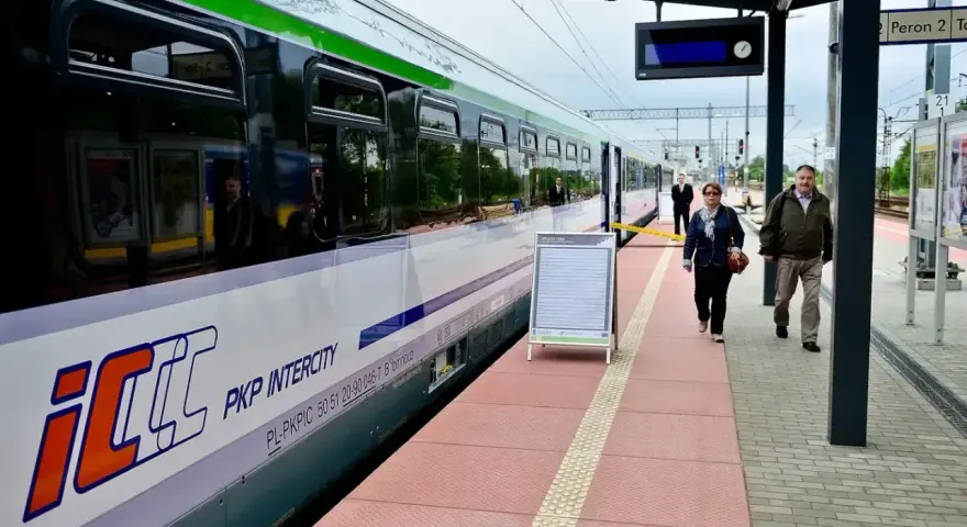 PKP Intercity na peronie. Tablica informacyjna obok pociągu, może zawierać dane o zgubionych rzeczach, jak w biurze rzeczy znalezionych PKP.