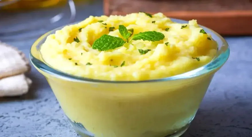Gładkie, kremowe puree ziemniaczane, idealne jako zmiksowane jedzenie dla chorego przepisy. Udekorowane listkami mięty i posypane ziołami.