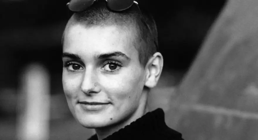 Sinéad O'Connor mit Sonnenbrille auf dem Kopf, ein nachdenklicher Blick. Ihr ikonischer Titel "Nothing Compares 2 U" hallt nach.