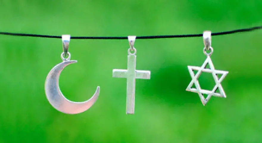 Srebrny półksiężyc, krzyż i gwiazda Dawida wiszą obok siebie. Symbolika islamu, chrześcijaństwa i judaizmu w harmonii.
