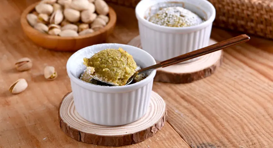 Un delicioso coulant de pistacho, recién horneado y espolvoreado con azúcar glas. ¡Una delicia para los sentidos!