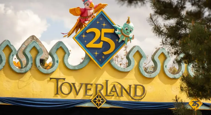 Bunte Figuren feiern 25 Jahre Toverland Freizeitpark. Ein Papagei und ein Oktopus zieren das Jubiläumslogo über dem Eingang.