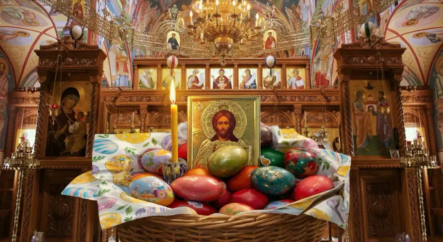A basket of colorful Easter eggs sits before an icon of Jesus in a richly decorated church, hinting at when Easter is celebrated in Europe.