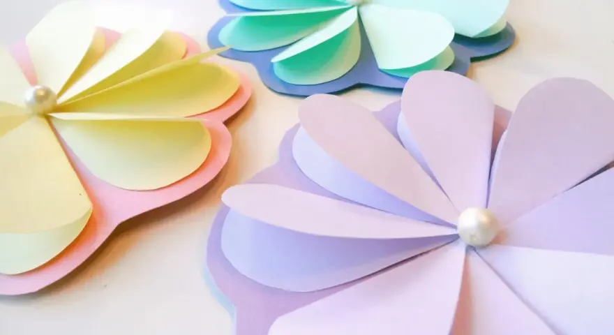 Pyssel vårblommor i pastellfärger. Tre pappersblommor med pärlor i mitten, perfekta för vårens dekorationer.