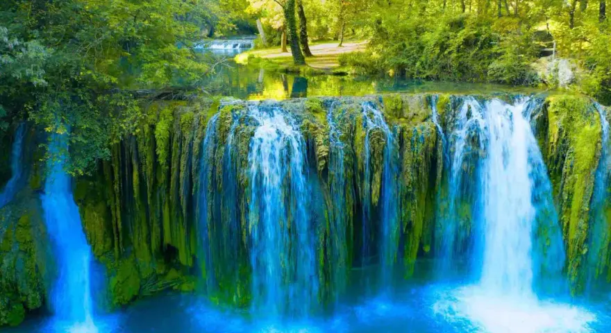 Cascata rigogliosa in Toscana, ideale per escursioni nella natura. Acqua cristallina e vegetazione lussureggiante creano uno scenario incantevole.