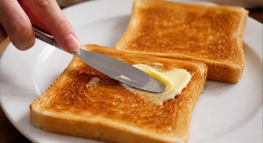 Goldbraunes Brot im Ofen getoastet, wird nun mit Butter bestrichen. Ein Genuss!