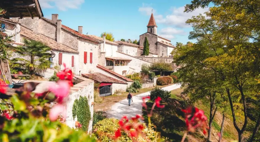 Un homme se promène dans un village pittoresque du Tarn-et-Garonne, une belle activité en plein air.