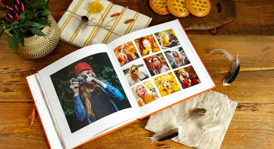 Otwarty album ze zdjęciami, idealny program do segregacji zdjęć, prezentuje jesienne portrety i psa wśród liści.