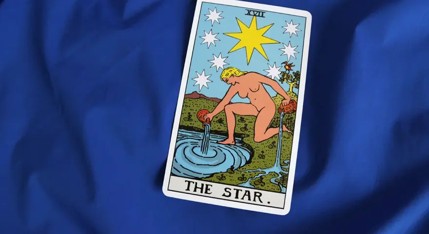 Karta XVII - Gwiazda Tarot. Kobieta wylewa wodę z dzbanów do stawu, symbolizując nadzieję i odnowę.