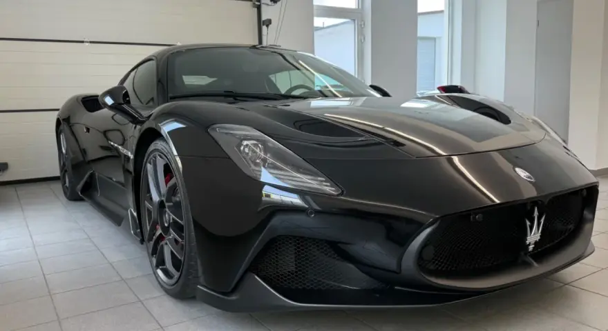 Czarny Maserati MC20 w garażu, widok z przodu.