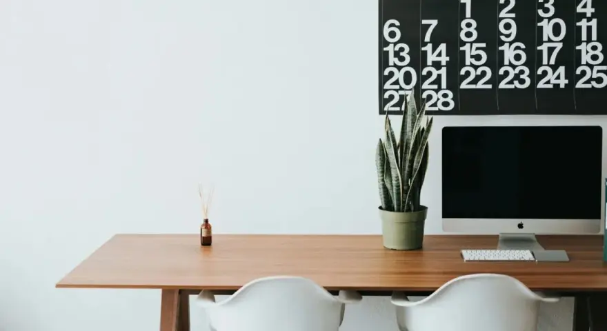 Escritorio moderno con ordenador, planta y calendario. Ideal para organizar tus aplicaciones de escritorio en la nube.
