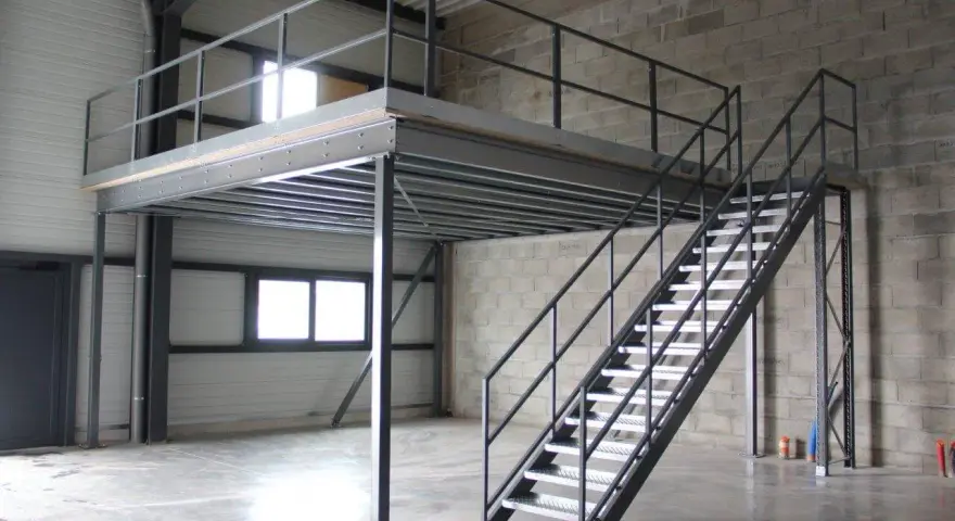 Escalier métallique menant à une création mezzanine dans un entrepôt. Structure industrielle fonctionnelle.