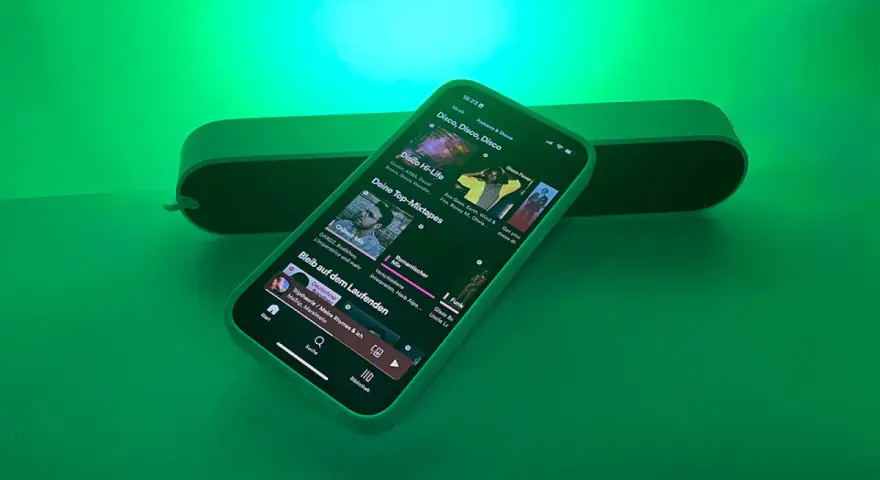 iPhone mit Spotify-App, das Disco-Musik abspielt, beleuchtet von Philips Hue Licht.
