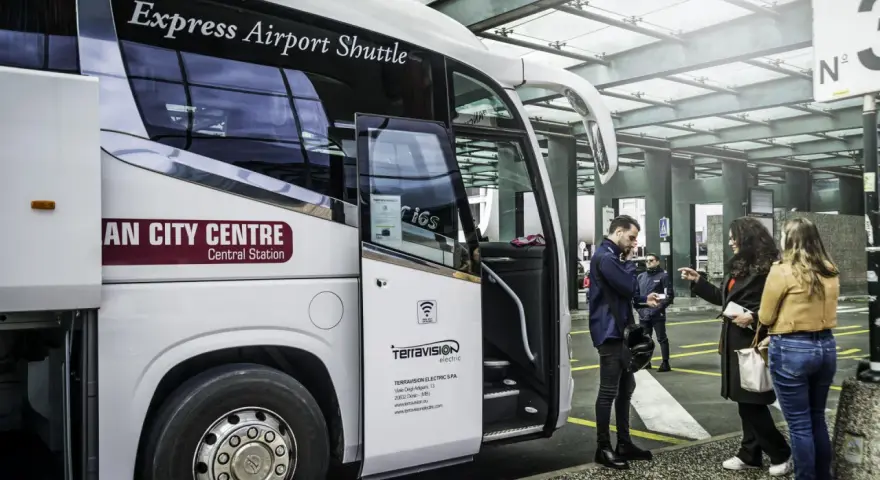 Autobus Express Airport Shuttle z napisem "AN CITY CENTRE Central Station" czeka na pasażerów. Podróż z Mediolan Malpensa do centrum jest prosta.