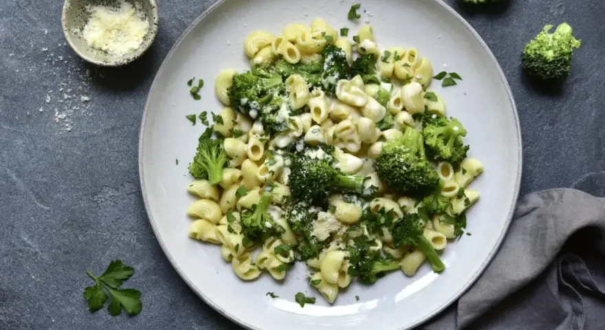 Pasta con brócoli cremosa, espolvoreada con queso rallado y perejil fresco. Un plato sencillo y delicioso.
