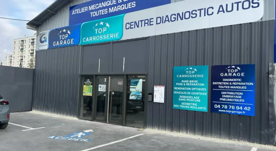 Façade d'un centre automobile avec des panneaux "Top Garage", "Top Carrosserie" et "Centre Diagnostic Autos".