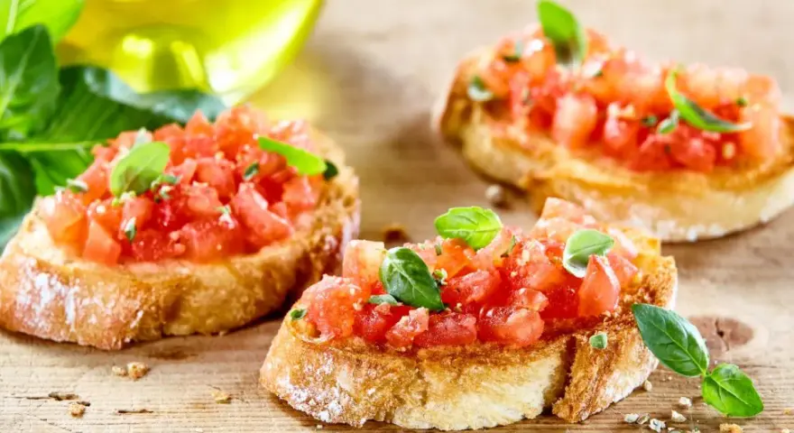 Bruschetta z pomidorami i mozzarellą – pyszny przepis na letnią przekąskę. Chrupiące grzanki z soczystymi pomidorami i świeżą bazylią.