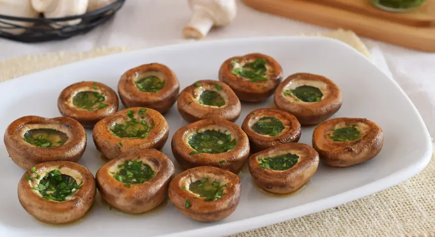 Champiñones a la plancha, dorados y rellenos de perejil fresco, listos para disfrutar.