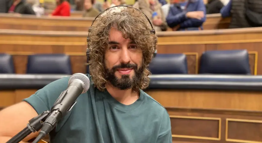 Mikel Izal, con su melena rizada y barba, sonríe ante el micrófono, listo para crear su propio paraíso musical en este escenario.