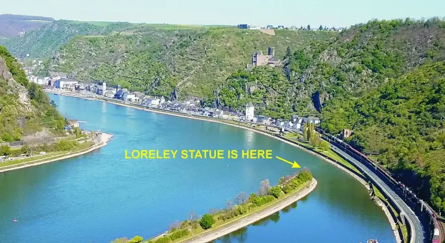 En vidsträckt vy över Loreleis flod, med en stad längs stranden och en järnväg som löper längs floden.