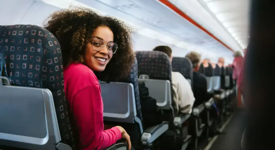 Smiling woman on a discount airlines european flight. She's happy to be traveling affordably.