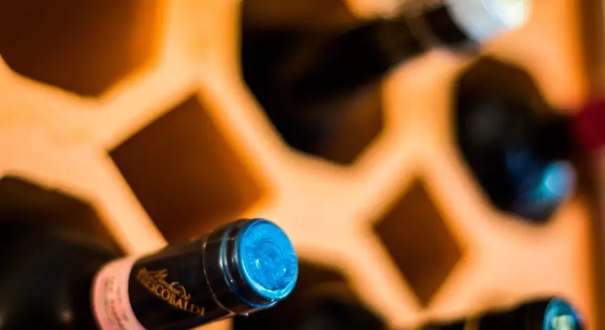 Butelki w drewnianym stojaku, jedna z etykietą "Frescobaldi". Ciekawi mnie, jak smakuje brandy.