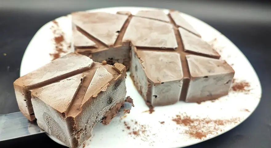Un delizioso semifreddo al cioccolato, tagliato a cubetti e spolverato con cacao, pronto per essere gustato.